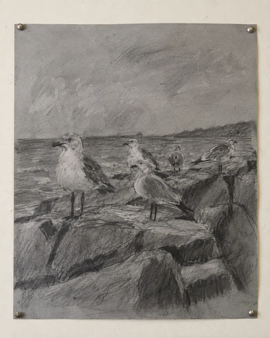 A smudgy charcoal drawing of gulls standing on a stone breakwater above a grey sea